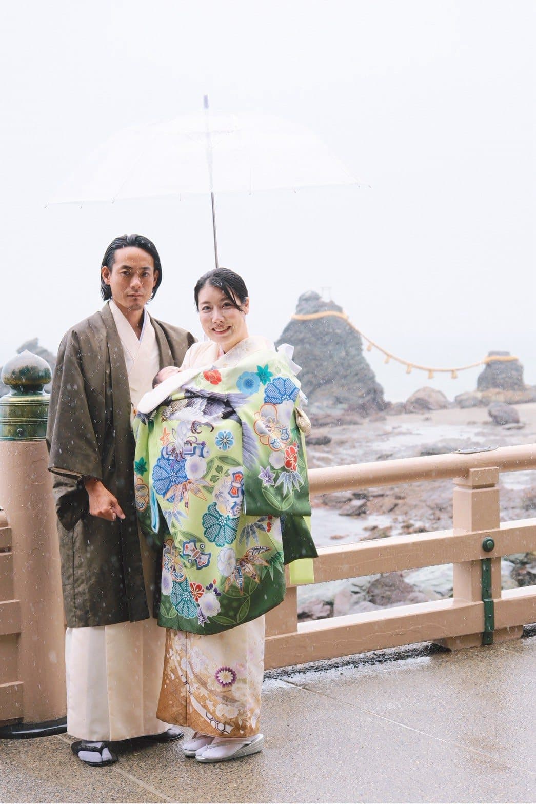 夫婦岩での家族写真。雨のなか和装で赤ちゃんを抱いている